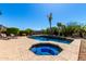 Swimming pool and spa surrounded by a patio deck and desert landscaping at 41961 W Centennial Rd, Maricopa, AZ 85138