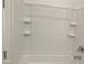 Clean white bathroom with tiled shower and built-in shelves at 4330 N 94Th Ave, Phoenix, AZ 85037
