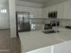 Modern kitchen features stainless steel appliances, white cabinetry, and a central island with a sink at 4330 N 94Th Ave, Phoenix, AZ 85037