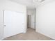 A bedroom with white walls, carpet, a ceiling fan, a closet and an open door at 44583 W Windrose Dr, Maricopa, AZ 85138