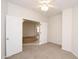 Inviting bedroom with neutral walls, carpeted flooring, and double doors leading into the living room at 44583 W Windrose Dr, Maricopa, AZ 85138