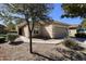 A single-Gathering home showcasing desert landscaping, a neutral-toned exterior, and an attached two-car garage at 44583 W Windrose Dr, Maricopa, AZ 85138