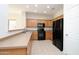 Functional kitchen featuring black appliances, tile floors, wood cabinets, and ample countertop space at 44583 W Windrose Dr, Maricopa, AZ 85138