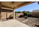This backyard features a covered patio with fan, rock landscaping and block wall at 45071 W Yucca Ln, Maricopa, AZ 85139