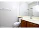 Bathroom featuring a single sink set into a wooden cabinet and a toilet at 45071 W Yucca Ln, Maricopa, AZ 85139