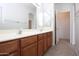 Bathroom featuring double sinks set into wood cabinets with a large mirror at 45071 W Yucca Ln, Maricopa, AZ 85139