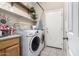 Well-organized laundry room with washer, dryer, shelving, and ironing board at 4552 E County Down Dr, Chandler, AZ 85249
