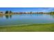 Scenic view of a serene lake surrounded by lush grass, enhancing the community's beauty at 4552 E County Down Dr, Chandler, AZ 85249