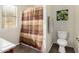 Bathroom features a shower with a brown striped shower curtain and a nearby white toilet at 45564 W Sheridan Rd, Maricopa, AZ 85139
