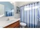 Modern bathroom with blue striped shower curtain, single sink vanity and a nearby white toilet at 45564 W Sheridan Rd, Maricopa, AZ 85139