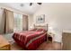Comfortable bedroom featuring a queen bed, wood floors, ceiling fan and window views at 45564 W Sheridan Rd, Maricopa, AZ 85139