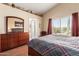Cozy main bedroom featuring a large dresser and a side chair with vaulted ceilings at 45564 W Sheridan Rd, Maricopa, AZ 85139