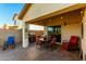 Covered patio with outdoor kitchen, dining set, lounge chair, and decorative string lights for cozy outdoor living at 45564 W Sheridan Rd, Maricopa, AZ 85139