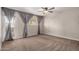 Neutral bedroom boasts a ceiling fan, carpet, and door with gray curtains at 4940 E Grandview St, Mesa, AZ 85205
