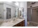 Well-lit bathroom featuring a large mirror, vanity with wood cabinets, and a walk-in shower at 520 S Greenfield Rd # 22, Mesa, AZ 85206