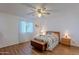 Serene bedroom with hardwood floors, a ceiling fan, a comfortable bed, and natural light from the window at 520 S Greenfield Rd # 22, Mesa, AZ 85206