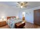 Cozy bedroom featuring a ceiling fan, wood floors, and access to an ensuite bathroom at 520 S Greenfield Rd # 22, Mesa, AZ 85206