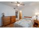 Inviting bedroom with ceiling fan, wood floors, and view to a dresser and nightstand at 520 S Greenfield Rd # 22, Mesa, AZ 85206