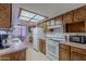 Classic kitchen featuring classic cabinetry, white appliances, and a view of the adjoining dining room at 520 S Greenfield Rd # 22, Mesa, AZ 85206