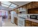 Functional kitchen featuring classic cabinetry, white appliances, and a view of the adjoining dining area at 520 S Greenfield Rd # 22, Mesa, AZ 85206