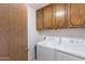 Laundry room features white washer and dryer with wood cabinets above at 520 S Greenfield Rd # 22, Mesa, AZ 85206