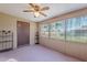 Enclosed sunroom features neutral walls, a ceiling fan and windows overlooking the yard and letting in natural light at 520 S Greenfield Rd # 22, Mesa, AZ 85206