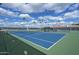 Well-maintained blue tennis court surrounded by lush greenery and clear skies at 520 S Greenfield Rd # 22, Mesa, AZ 85206