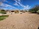Large backyard with desert landscaping and a view of the house with its covered patio at 5812 S Staghorn Cholla Ct, Gold Canyon, AZ 85118