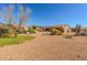 Desert landscape in backyard featuring arid plants and a glimpse of the house and patio at 5812 S Staghorn Cholla Ct, Gold Canyon, AZ 85118