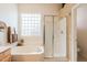 Bright bathroom showcasing a glass block window, soaking tub, and a separate glass-enclosed shower at 5812 S Staghorn Cholla Ct, Gold Canyon, AZ 85118