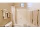 Bright bathroom features a shower with white tile and decorative window at 5812 S Staghorn Cholla Ct, Gold Canyon, AZ 85118