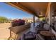 Charming covered patio with outdoor seating and lush desert landscaping, creating a relaxing and inviting outdoor living space at 5812 S Staghorn Cholla Ct, Gold Canyon, AZ 85118