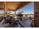 Inviting covered patio with comfortable wicker seating, stylish decor, and views of the lush desert landscaping, perfect for relaxation at 5812 S Staghorn Cholla Ct, Gold Canyon, AZ 85118