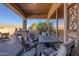 Charming covered patio with a cozy dining area, comfortable seating, and elegant decor, perfect for outdoor dining and relaxation at 5812 S Staghorn Cholla Ct, Gold Canyon, AZ 85118