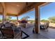 Relaxing covered patio featuring desert landscaping, seating, and stylish decor, ideal for enjoying the outdoors in comfort at 5812 S Staghorn Cholla Ct, Gold Canyon, AZ 85118