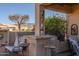 Stylish covered patio with a bar area, comfortable seating, and decorative masks, creating a perfect space for outdoor entertaining at 5812 S Staghorn Cholla Ct, Gold Canyon, AZ 85118
