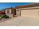 Welcoming home exterior featuring a two-car garage and a stone accented front patio at 5812 S Staghorn Cholla Ct, Gold Canyon, AZ 85118