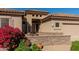 Charming home exterior with stone accents, a cozy front patio, and colorful landscaping at 5812 S Staghorn Cholla Ct, Gold Canyon, AZ 85118