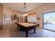 Bright game room with a classic billiard table and a sliding door leading to an outdoor patio at 5812 S Staghorn Cholla Ct, Gold Canyon, AZ 85118