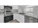 Modern kitchen with stainless steel appliances, granite countertops, and white cabinets at 604 E Weber Dr # 12, Tempe, AZ 85288