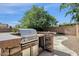 Close up view of the stone barbecue island in the backyard with stainless steel grill at 6204 S Banning St, Gilbert, AZ 85298