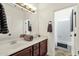 Well-lit bathroom featuring double sinks, wood cabinets, large mirror, and shower-tub combo at 6204 S Banning St, Gilbert, AZ 85298