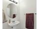 Compact powder room with oval mirror, pedestal sink, and neutral decor at 6204 S Banning St, Gilbert, AZ 85298