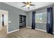 Bedroom features carpet, ceiling fan, blue curtains, and a walk-in closet at 6204 S Banning St, Gilbert, AZ 85298