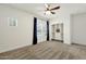 Carpeted bedroom with closet, ceiling fan, windows with curtains and neutral walls at 6204 S Banning St, Gilbert, AZ 85298