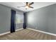 Bedroom features carpet, ceiling fan, and blue curtains, providing a comfortable and stylish space at 6204 S Banning St, Gilbert, AZ 85298