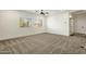 Spacious room with neutral carpet, large windows, and a ceiling fan at 6204 S Banning St, Gilbert, AZ 85298