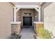 Inviting entryway with stone columns, a sheltered porch, and a dark double door at 6204 S Banning St, Gilbert, AZ 85298