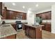 Kitchen boasts granite countertops, stainless appliances and dark wood cabinetry at 6204 S Banning St, Gilbert, AZ 85298