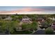An aerial view of a neighborhood featuring lush tree cover and well-maintained homes with tile roofs in warm sunlight at 8336 S Homestead Ln, Tempe, AZ 85284